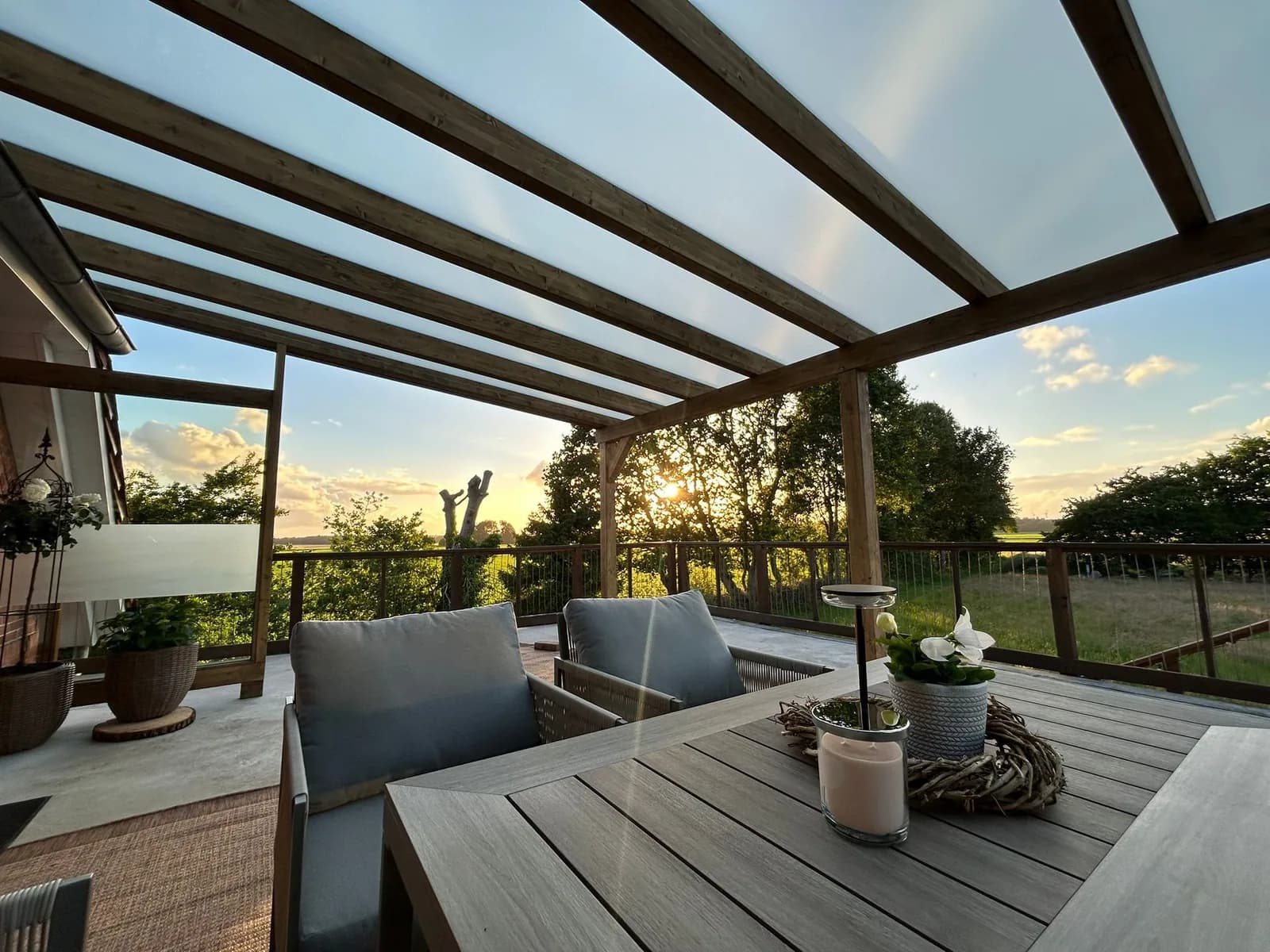 Fertige Terrassenüberdachung mit Glasdach in der Abenddämmerung