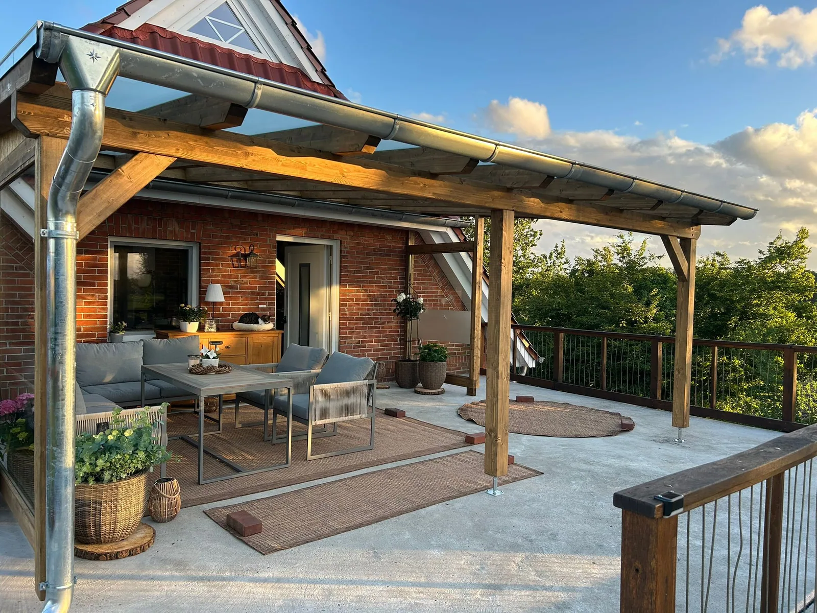 Fertige Terrasse mit Loungemöbeln unter dem Glasdach